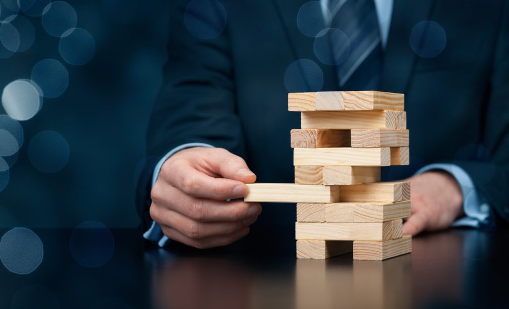 Businessman removes one piece from tower