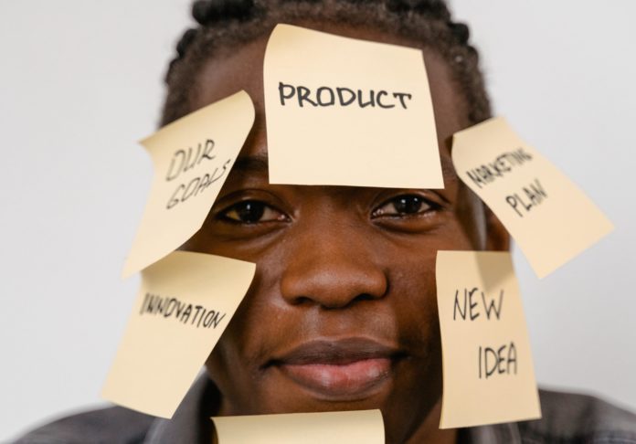 person with sticky notes about product management on their face
